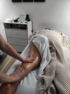 masaje-relajante-mujer-recostada-abajo-pies-manos-cama