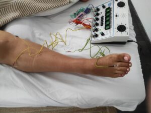 massaje-pie-aparato-medidor-cama-mujer-recostada-electro-acupuntura